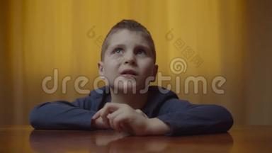 自闭症男孩坐在办公桌前表现情绪的肖像。 患有自闭症的孩子在家感到沮丧。 自闭症